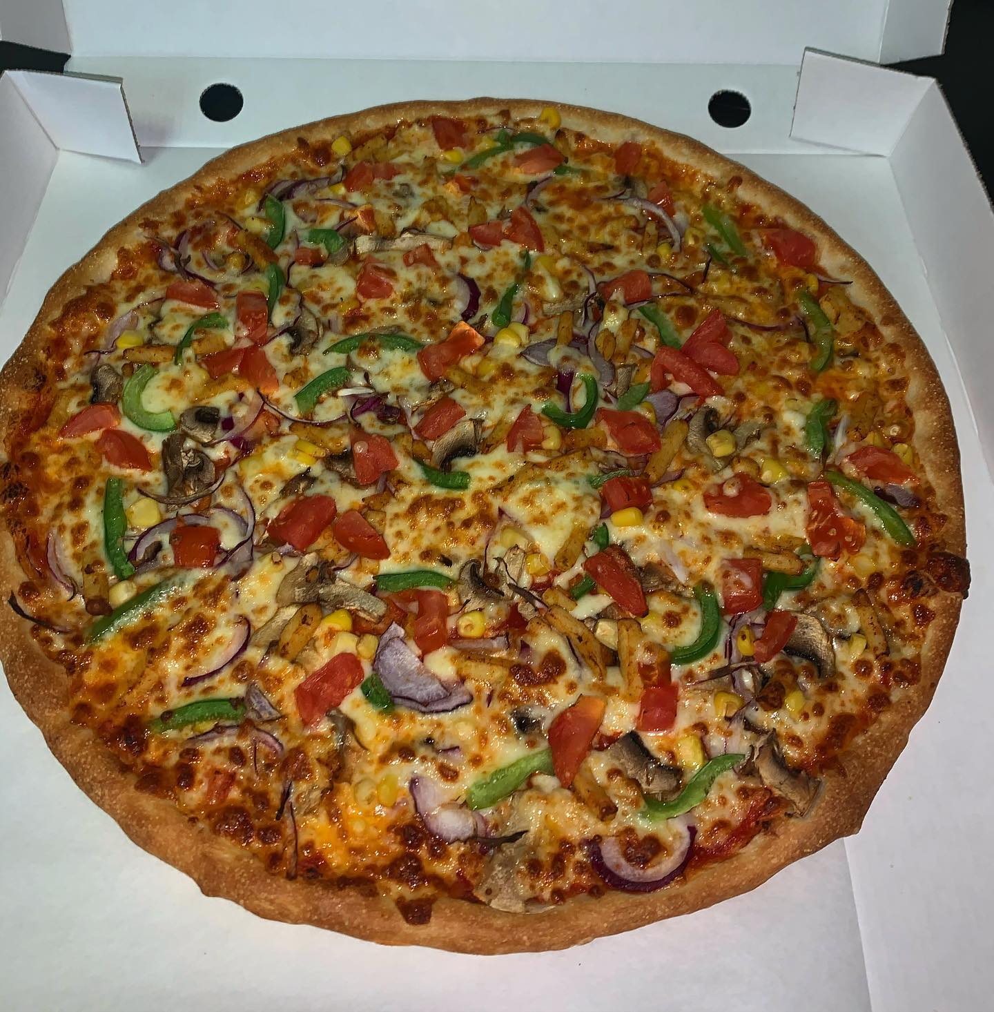 Pizza topped with green peppers, pepperoni and red onion