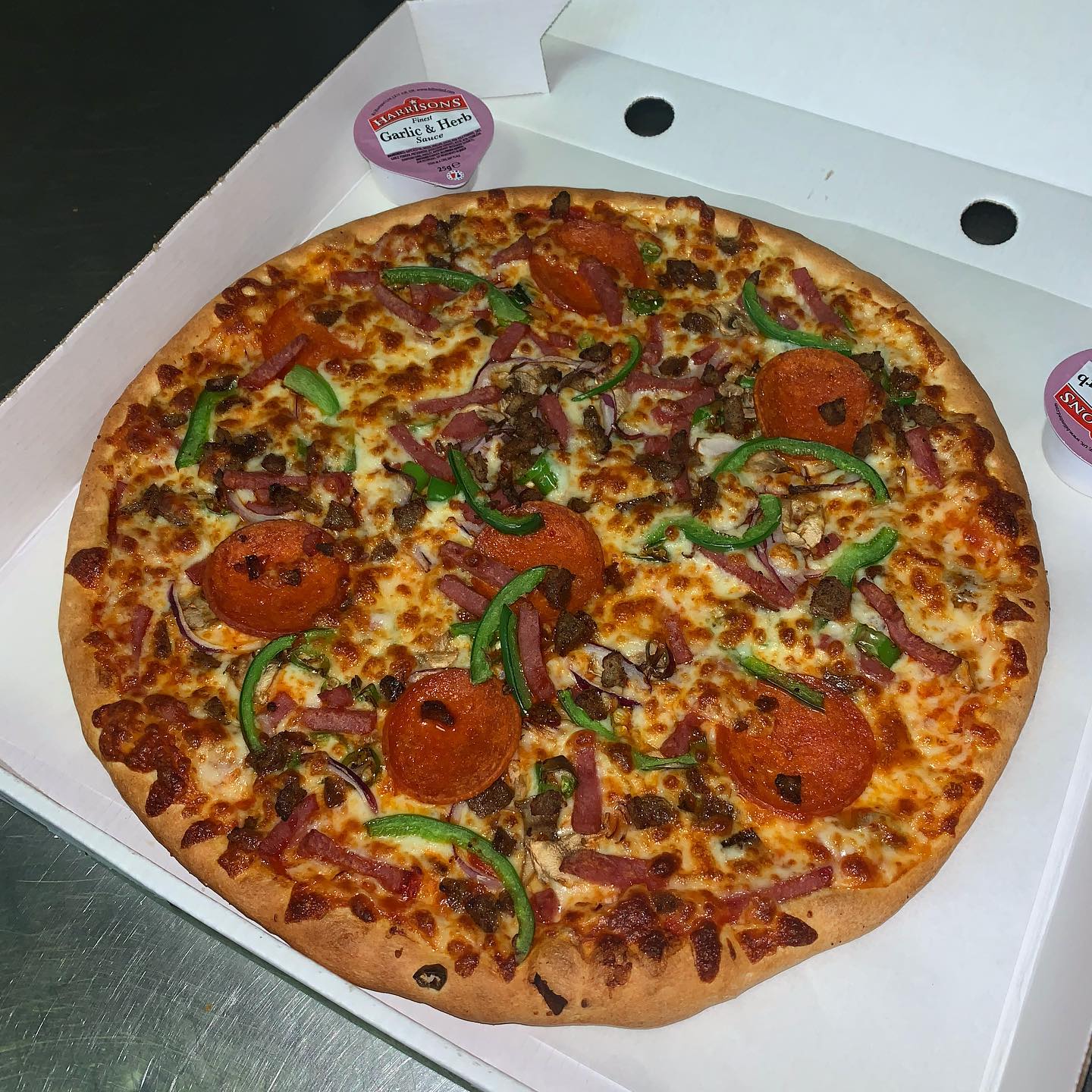Freshly baked loaded pizza in a box